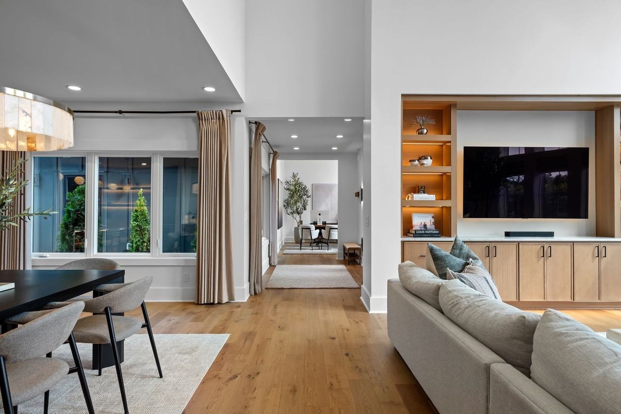 From the dining area toward the foyer and office, past the sectional and the media wall.