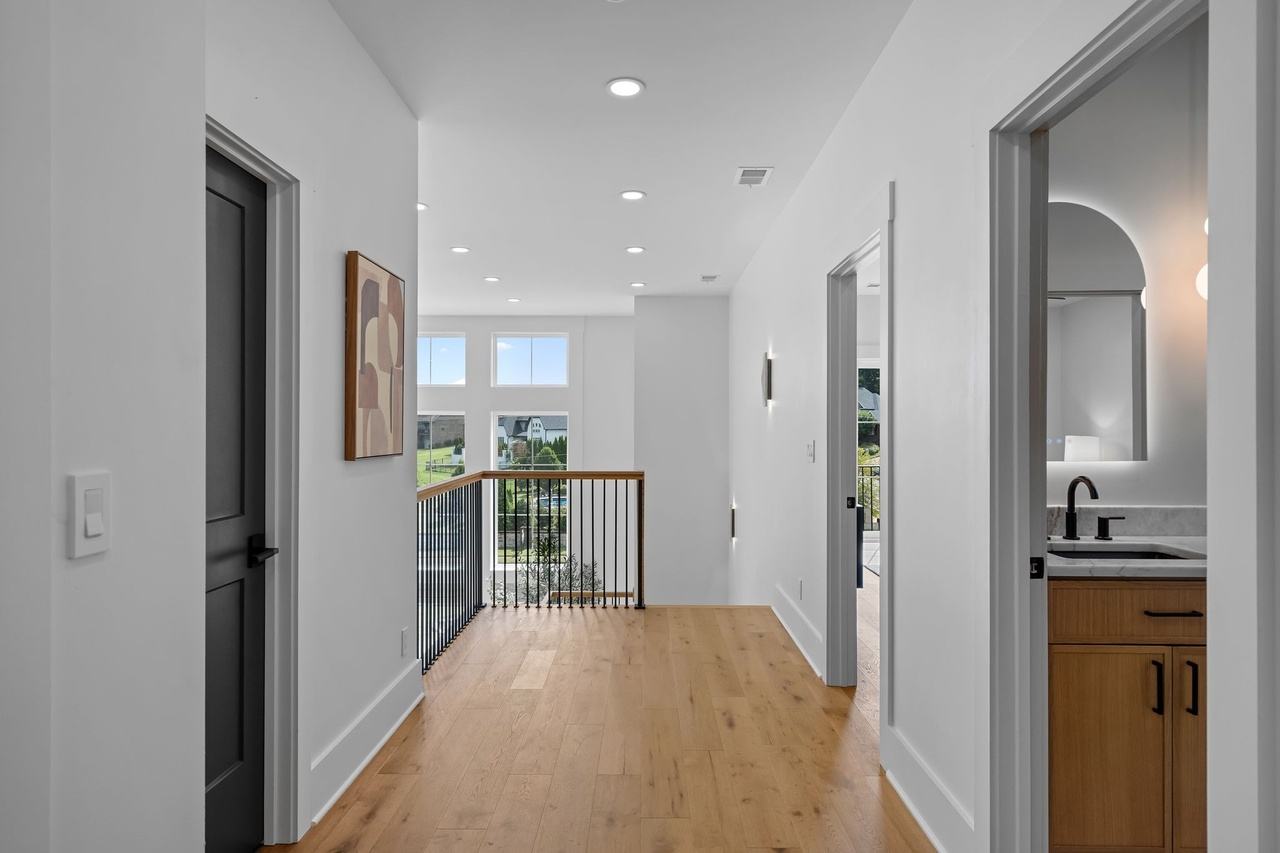 The upstairs hall, oak floors running to the railing over the living room.