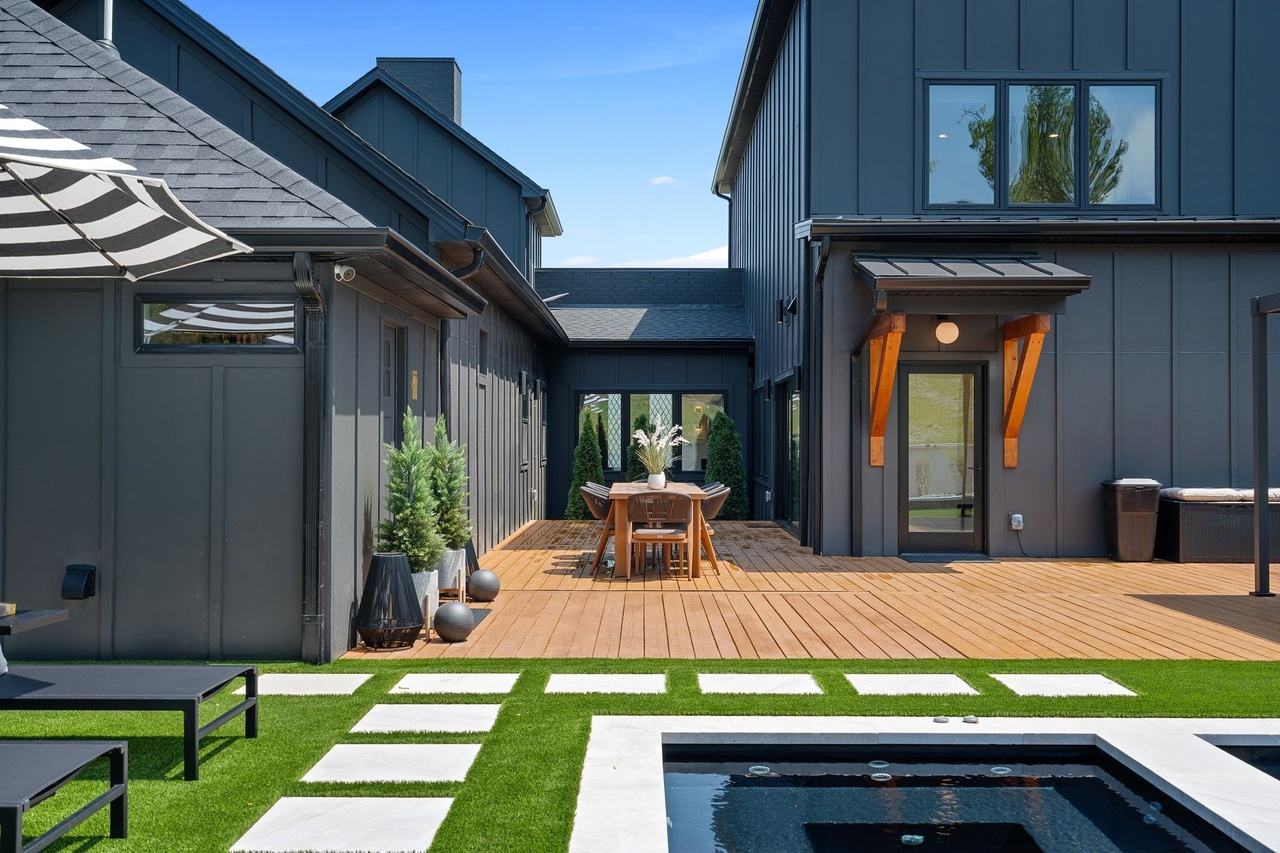 The deck toward the courtyard: an outdoor dining table for eight between conical topiaries.