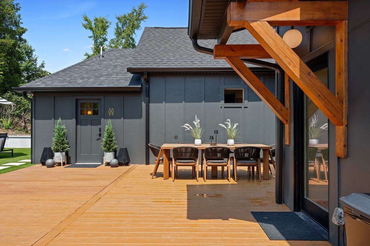 The outdoor dining table by the back entry, under the cedar brackets.