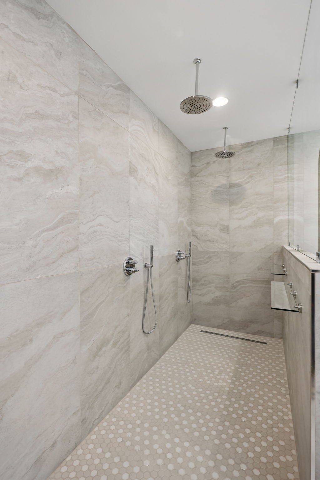 2025 photograph (before): Primary Bathroom, with 2 rain heads, hex mosaic floor, linear drain, gray tile