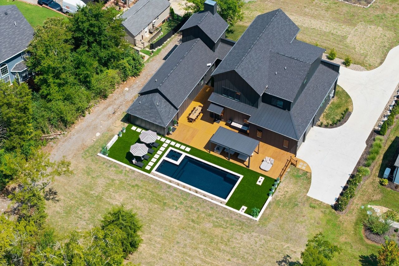 Aerial view over the yard: the pool, turf and pergola set behind the house.