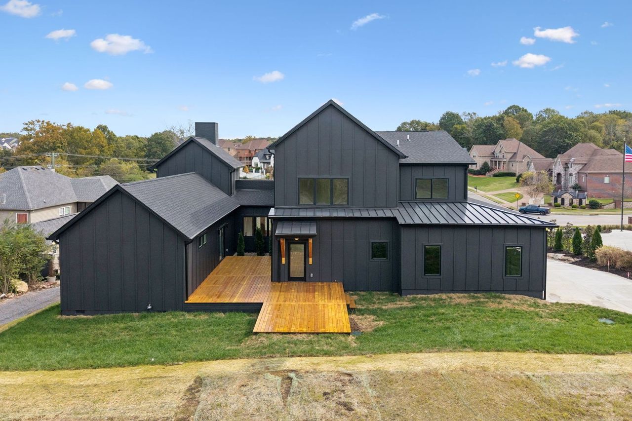 2025 photograph (before): Exterior Rear, with rear deck, timber awning, 3 window gable, brick chimney