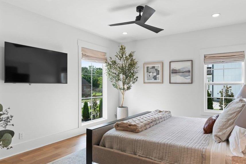 The downstairs guest bedroom from the doorway, an upholstered bed between fluted nightstands.