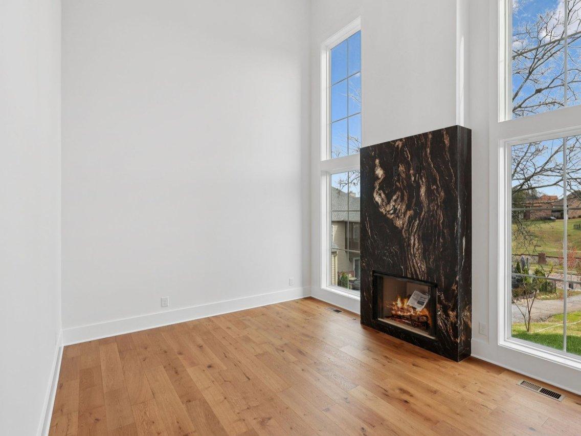 2025 photograph (before): the office, empty, a black marble fireplace surround between tall windows.