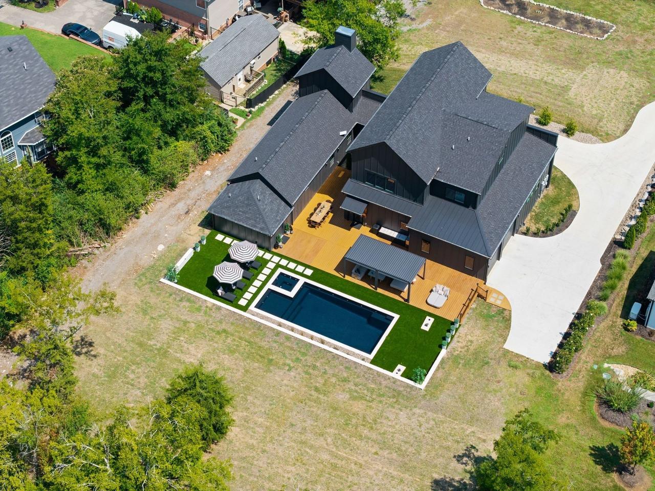 Aerial view over the yard: the pool, turf and pergola set behind the house.