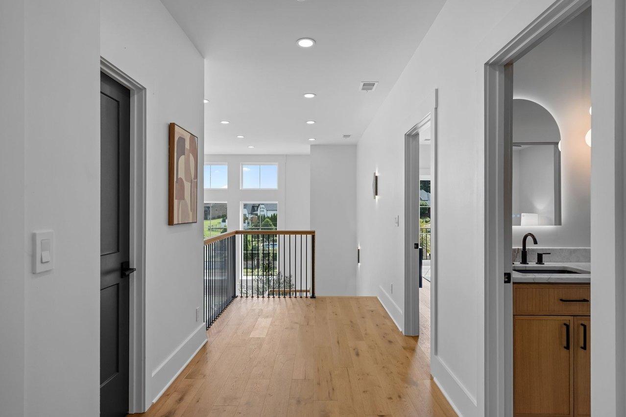 The upstairs hall, oak floors running to the railing over the living room.